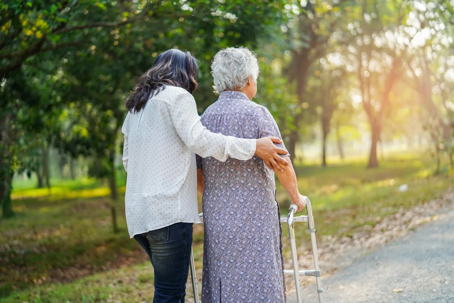 Praxis Grunewald – Logopädie & Physiotherapie – Hilfe und Pflege: Asiatische Seniorin oder ältere Dame mit guter Gesundheit nutzt Gehhilfe beim Spazierengehen im Park im schönen, erholsamen Urlaub.